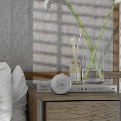 Lysegrå Mudita Harmony 2 soloppgangsvekkerklokke med E Ink-skjerm på nattbordet