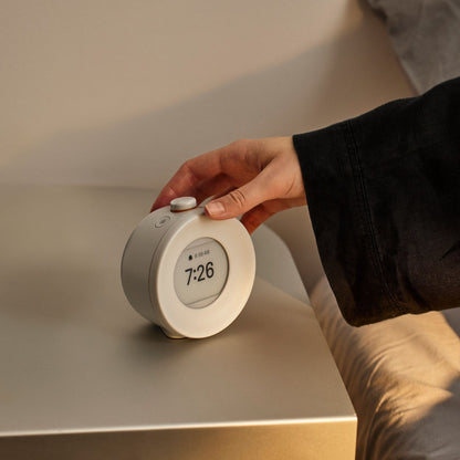Mudita Harmony Pebble Grey vekkerklokke på nattbordet med blålysfri e-ink skjerm som gir bedre søvn og mindre skjermstress.