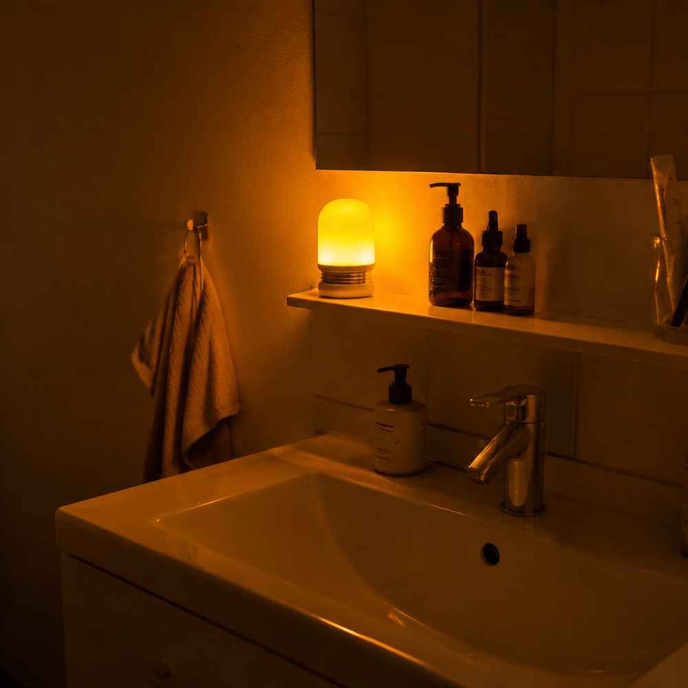 NoBlue nattlampe med varmt ravlys på badet om natten