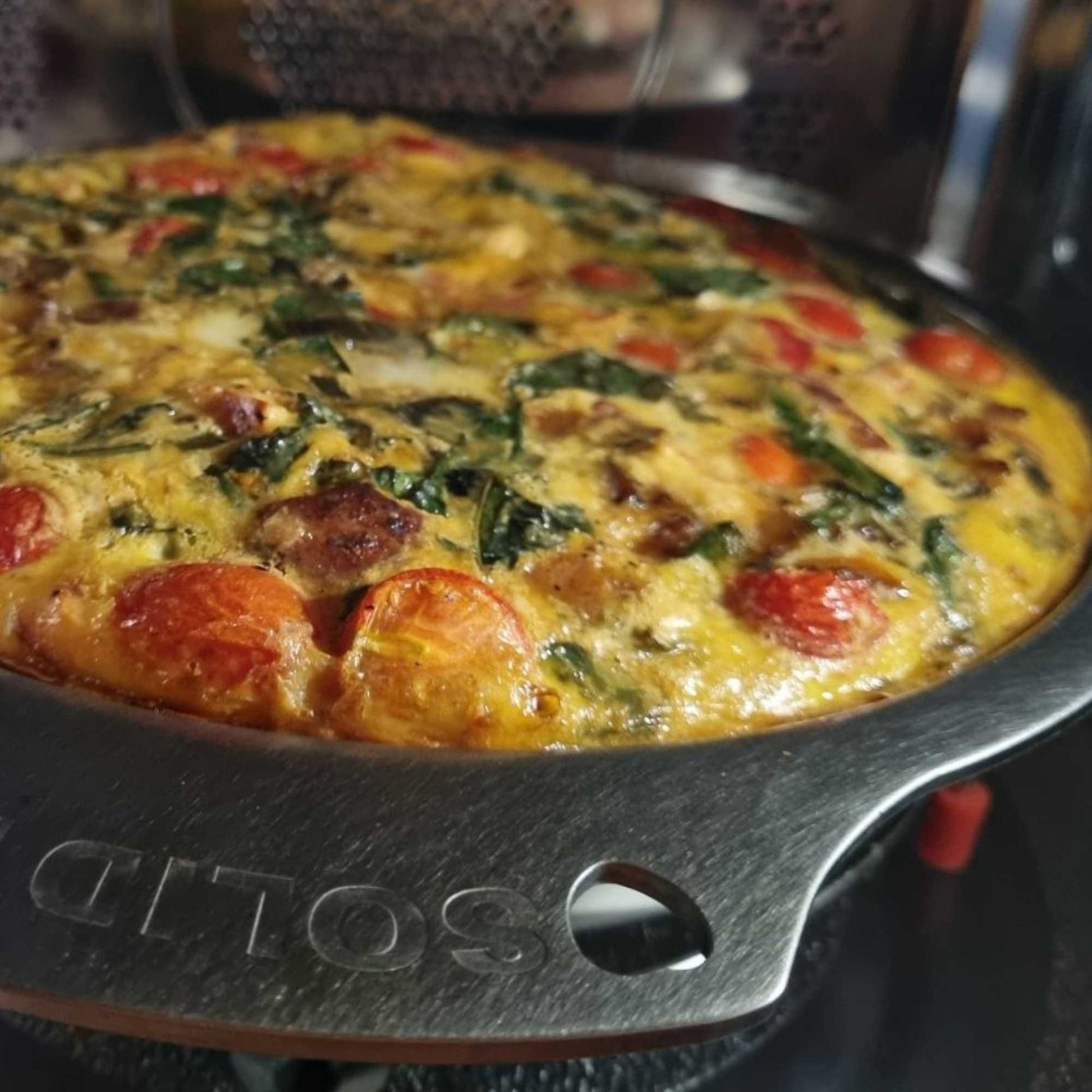 Frittata med tomat og grønt tilberedt i en Solidteknics nöni ovn-til-bord panne i nikkelfritt rustfritt stål.