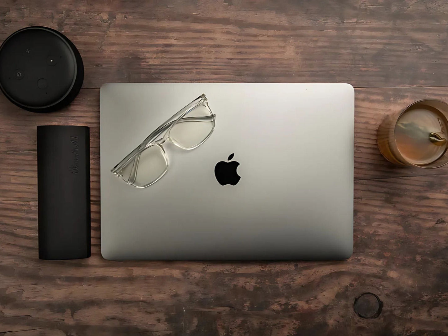 Parker klare blålysbriller med transparent innfatning liggende på MacBook ved siden av svart Ocushield etui