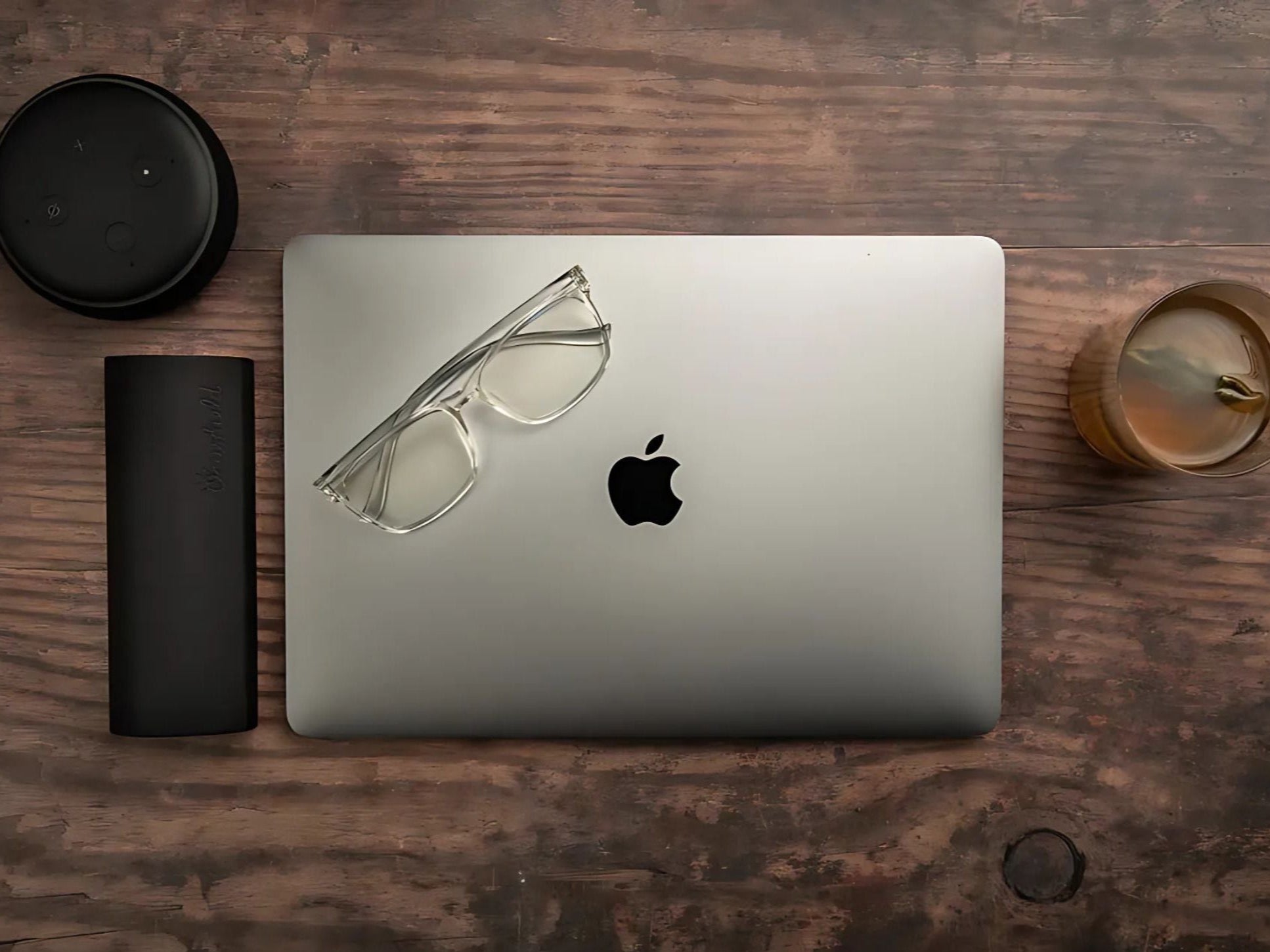 Parker klare blålysbriller med transparent innfatning liggende på MacBook ved siden av svart Ocushield etui