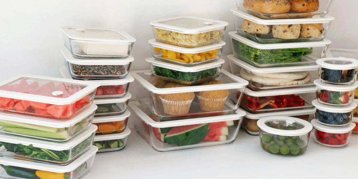 Plastfri matoppbevaring i glassbeholdere med glasslokk fylt med frukt, grønnsaker og middagsrester i kjøleskap.