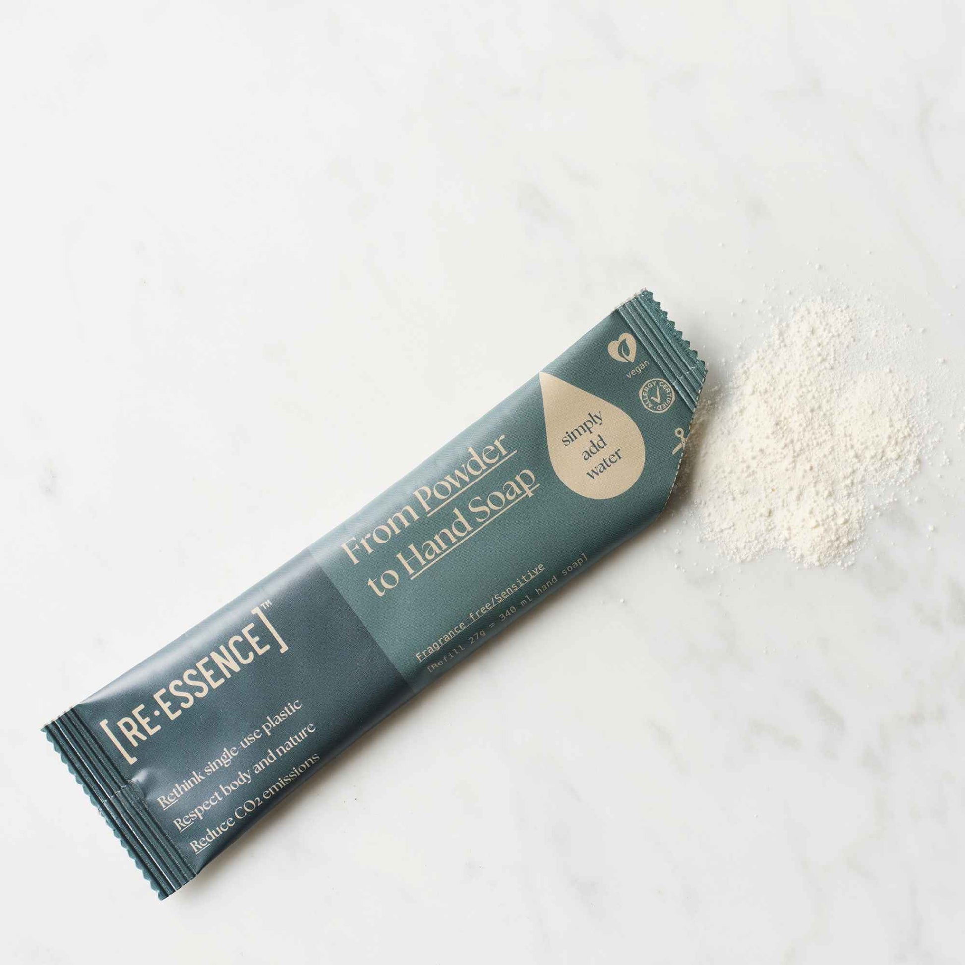 RE·ESSENCE pulverrefill til parfymefri håndsåpe med pulver ved siden av emballasjen.
