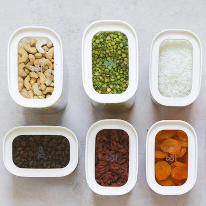 Rektangulære glassbeholdere med glasslokk fylt med nøtter, linser, ris, kaffe og tørket frukt – plastfri og ryddig pantryoppbevaring