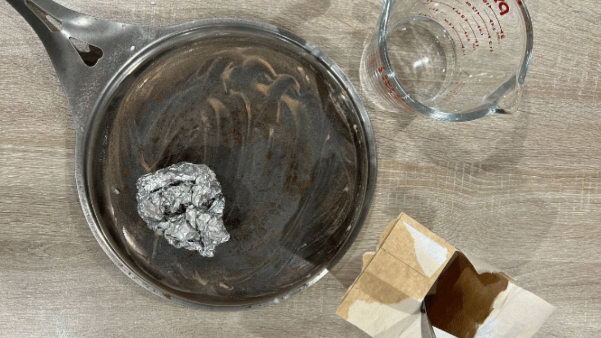 Undersiden av en nöni™-panne i nikkelfritt rustfritt stål rengjøres med natron og aluminiumsfolie