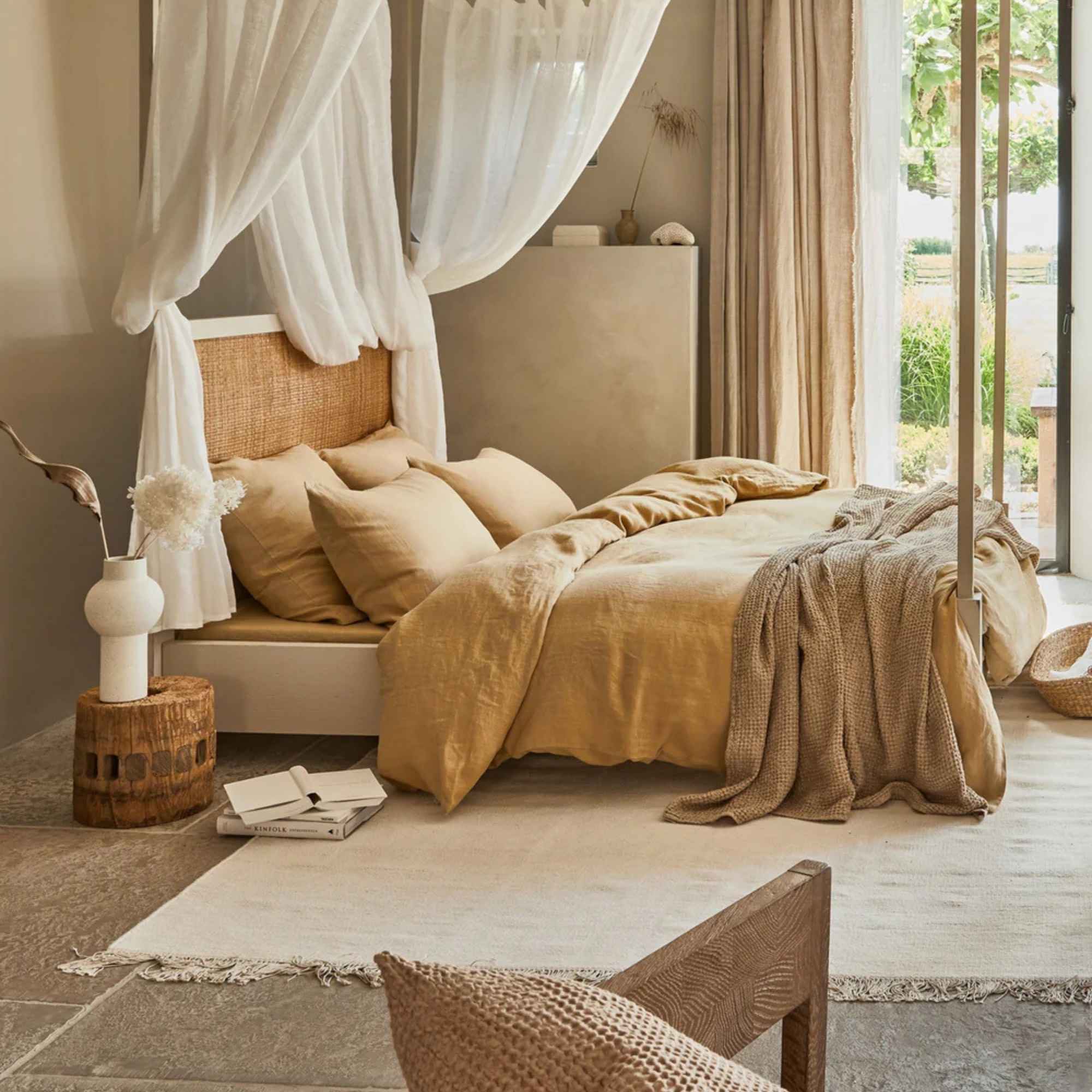 Beige sengeteppe i lin- og bomullsblanding lagt over seng i lyst, naturlig soverom med rolig interiør