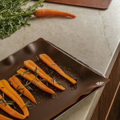 Clove silikonbakematte med gulrøtter klare for ovnsbaking, et gjenbrukbart non stick alternativ til engangs bakepapir.