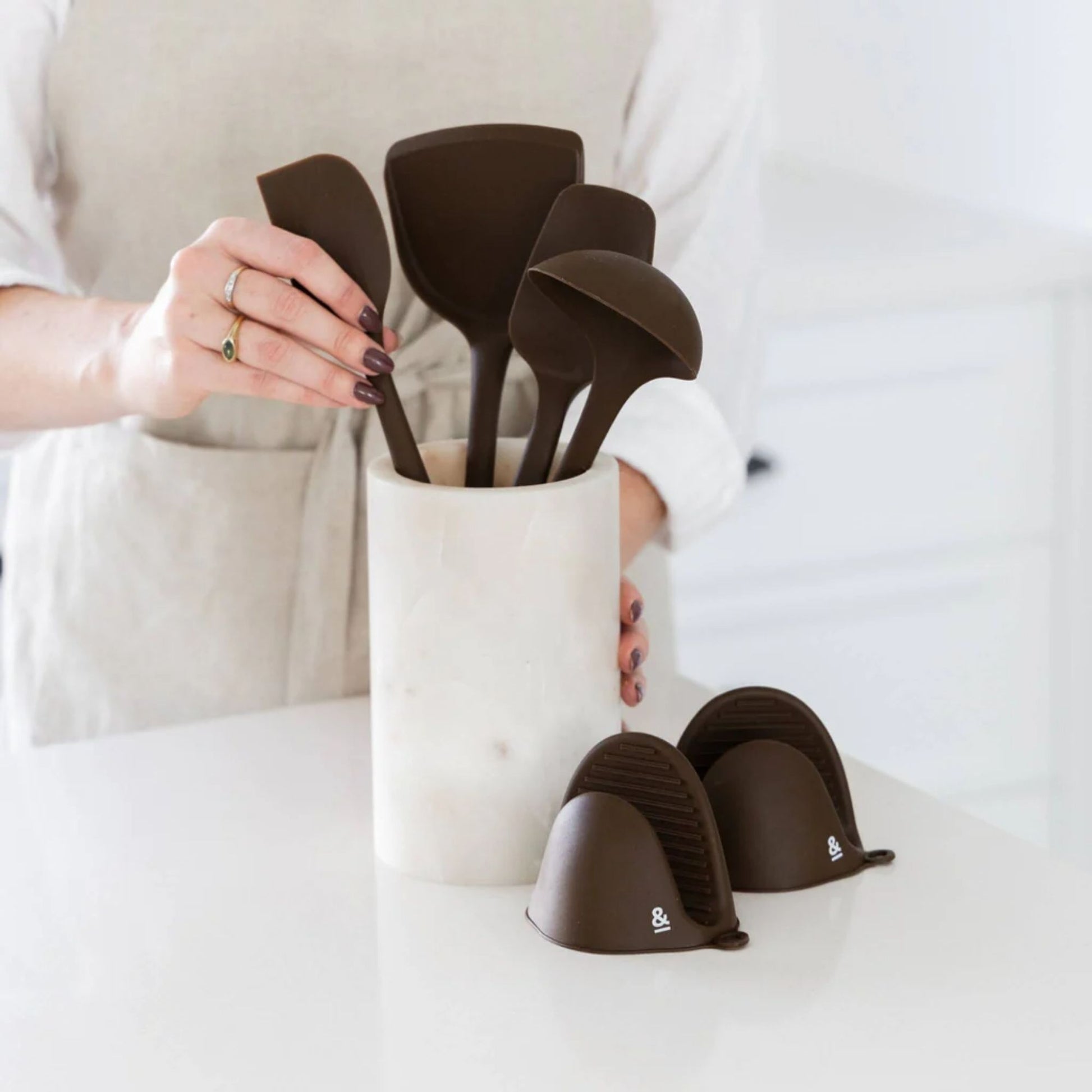 Person som holder silikon kjøkkenredskapssett i fargen Clove.