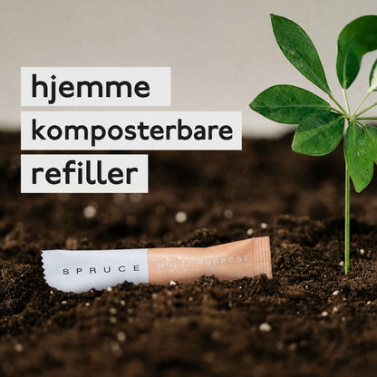 Spruce hjemmekomposterbar refill for naturlig rengjøring, vist i jord ved en grønn plante.