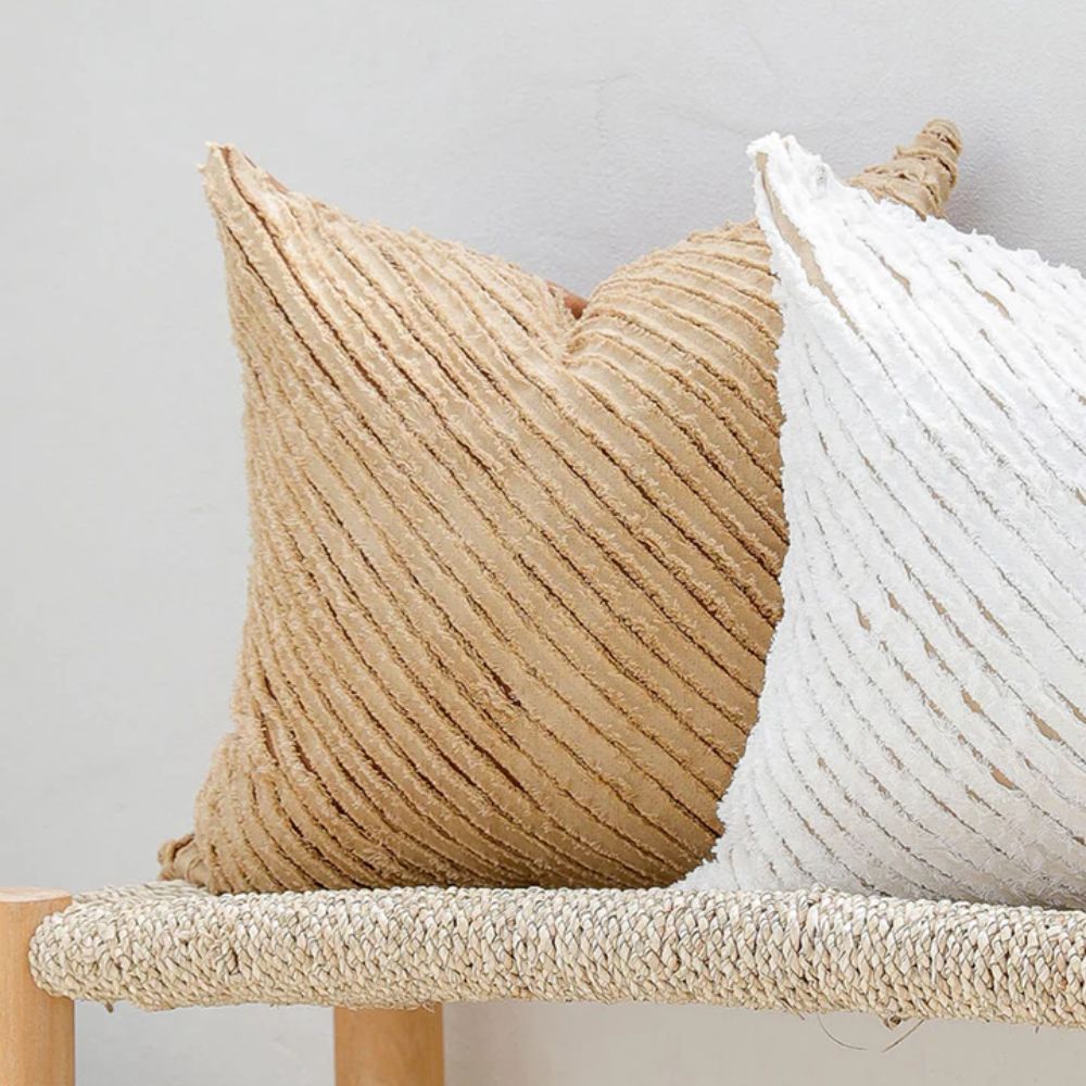 Stripete putetrekk i 100 % lin i beige og hvit, fra MagicLinen, vist på benk