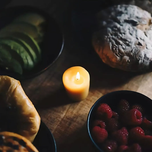 Allergivennlig økologisk bivokslys på et lyst og innbydende frokostbord med sunn mat, frisk frukt og naturlige materialer.