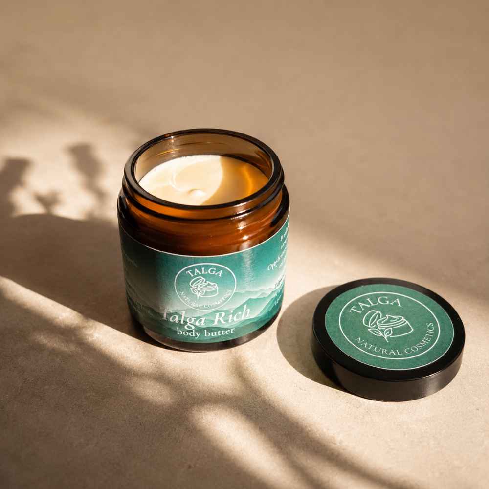 Talga Rich Body Butter i brun glasskrukke på varm beige bakgrunn med naturlig lys. Parfymefri og vannfri kroppskrem laget med gressforet norsk talg.