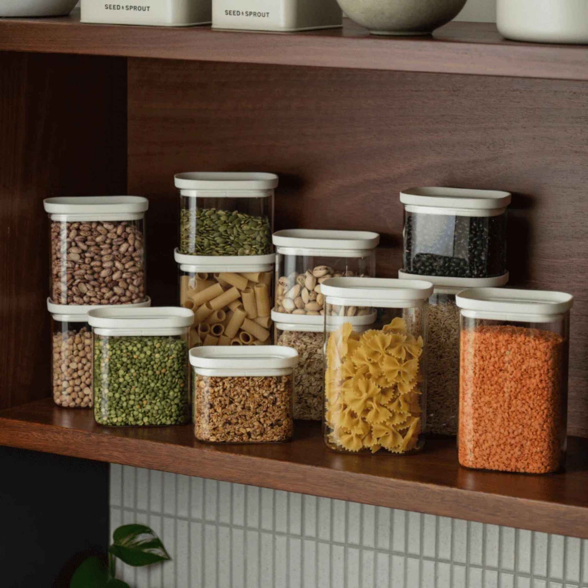 Tallow Pantry glassbeholdere med glasslokk i borosilikatglass fylt med pasta, linser og bønner til plastfri oppbevaring av tørrvarer i kjøkkenskap.