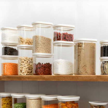 Plastfrie Tallow Pantry glassbeholdere med glasslokk fylt med tørrvarer, stablet ryddig på kjøkkenhylle