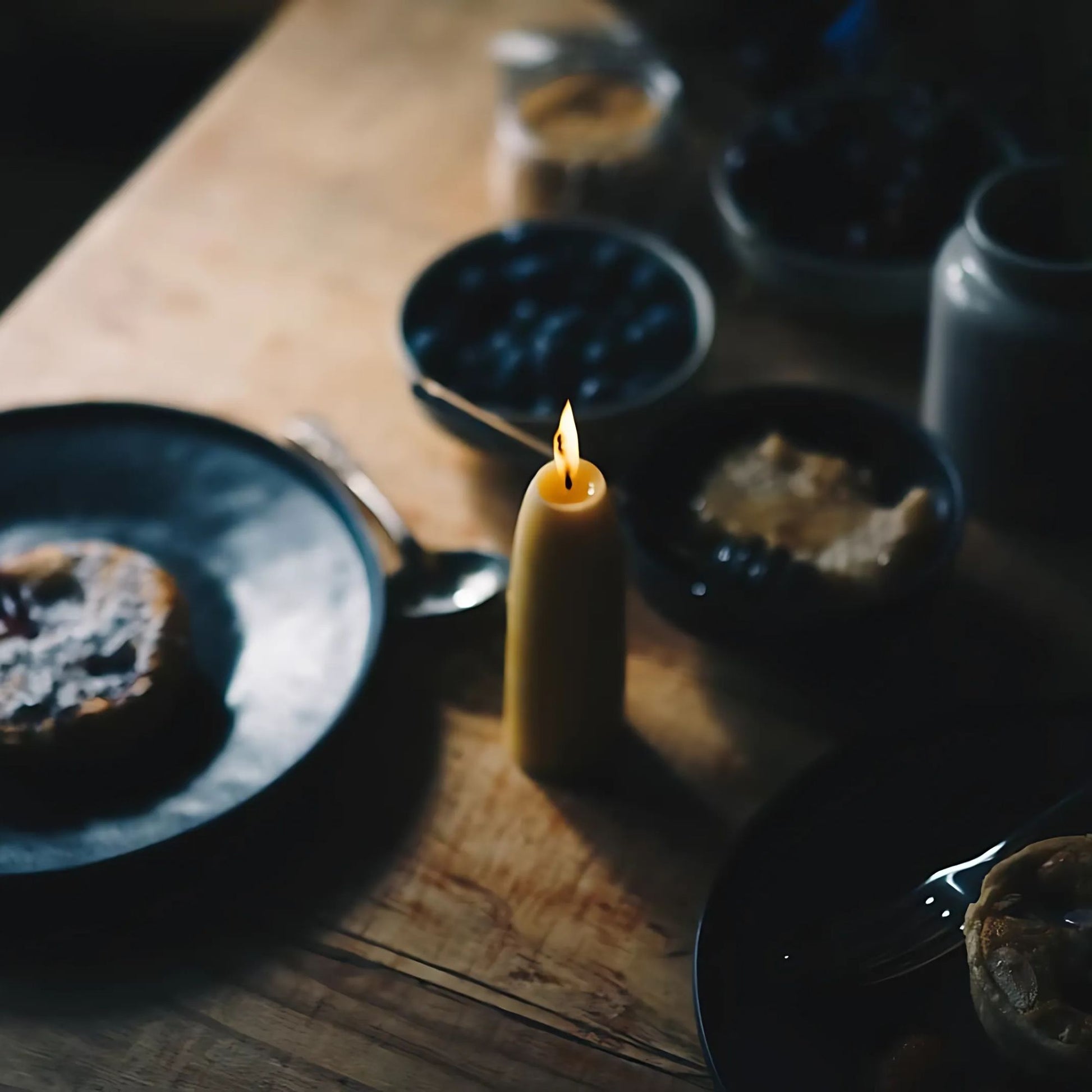 To økologiske stubbelys av bivoks skaper varmt og naturlig lys på et rolig frokostbord.