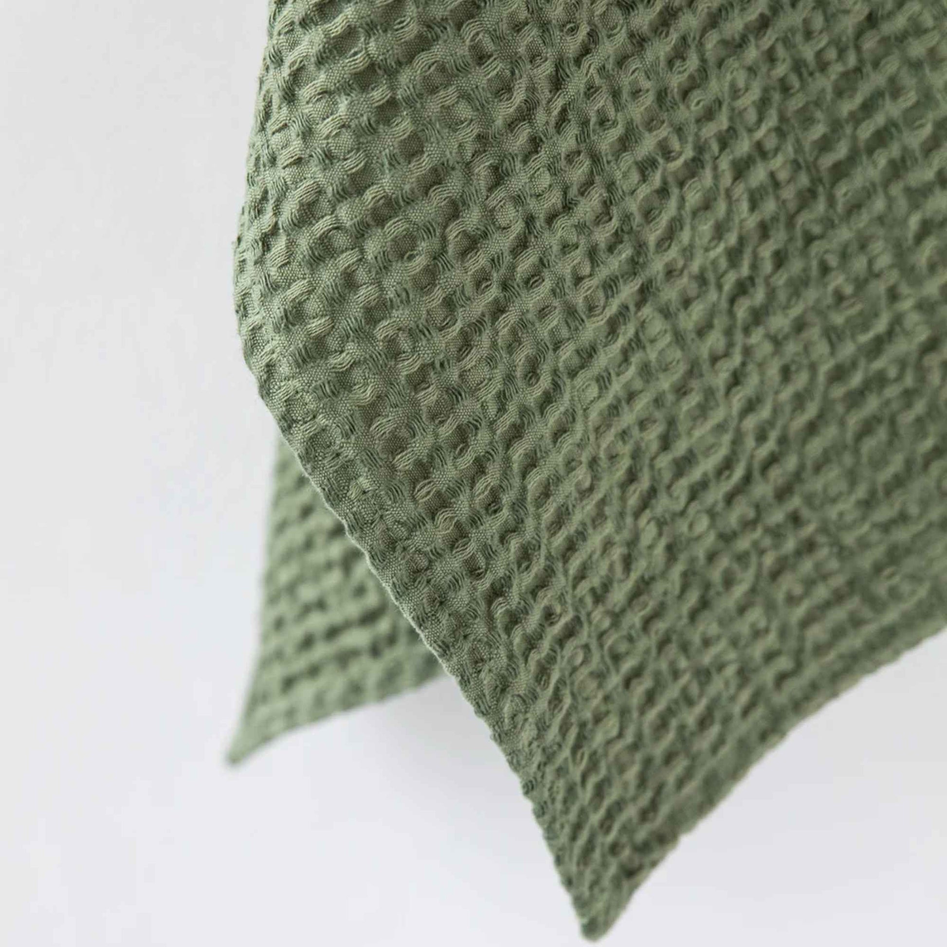 Nærbilde av vaffelvevd håndkle i Forest Green, laget av 53 % lin og 47 % bomull, som viser teksturen i stoffet.