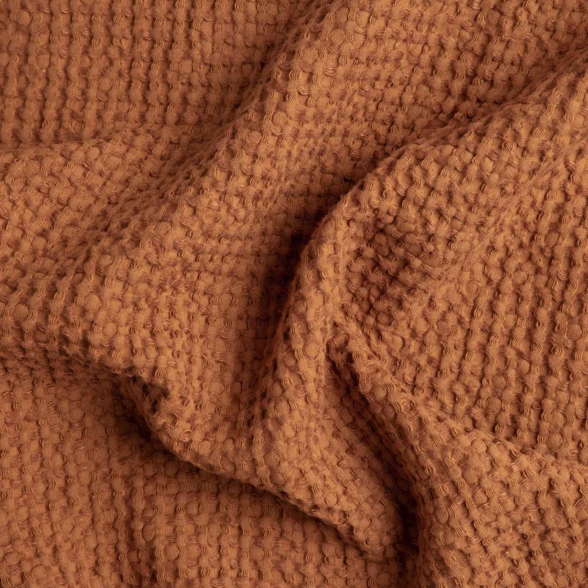 Nærbilde av vaffelvevd håndkle i kanelbrun (Cinnamon), laget av 53 % lin og 47 % bomull, som fremhever den myke teksturen og vaffelstrukturen.