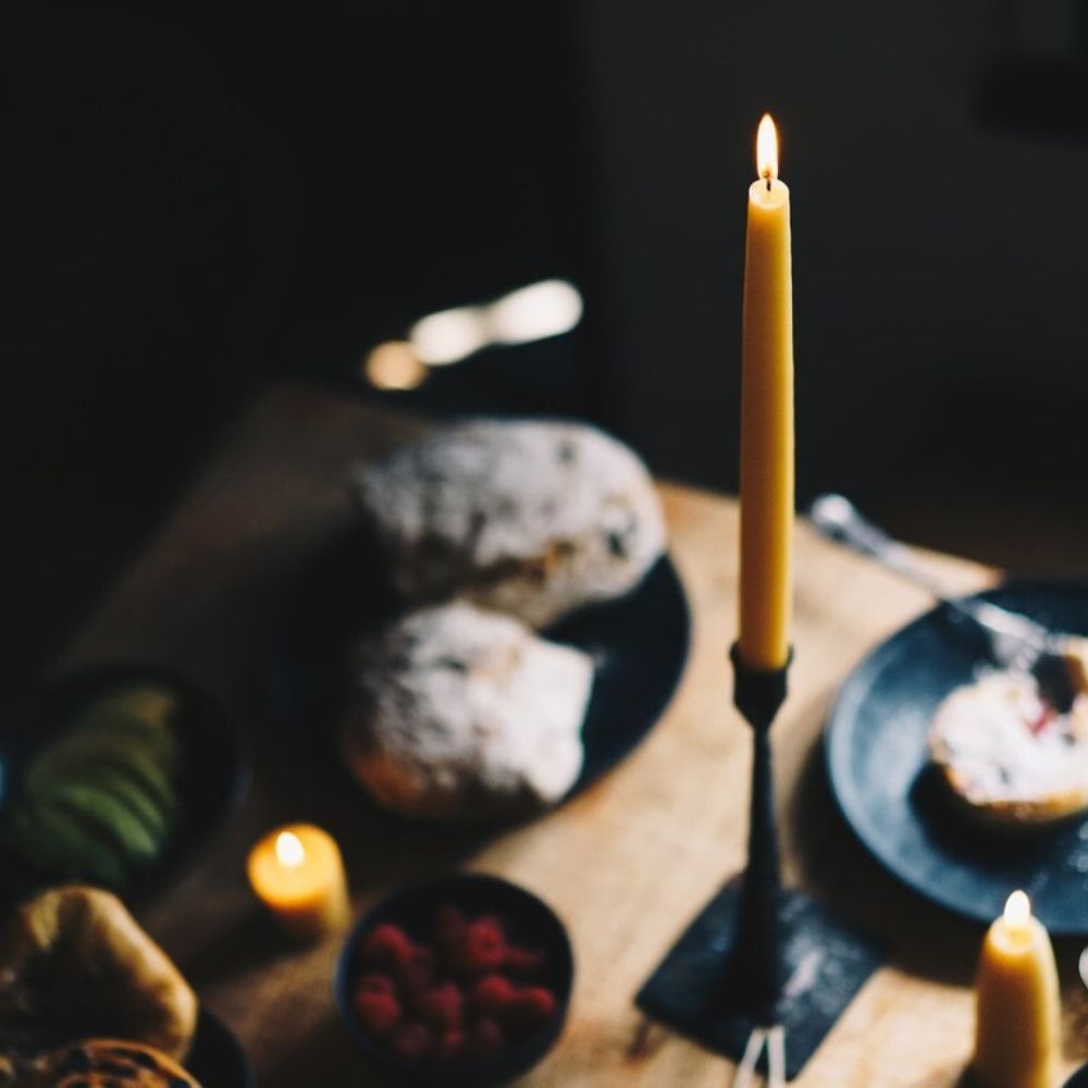 Votivlys laget av sertifisert økologisk bivoks på frokostbord, skaper naturlig og bærekraftig stemning