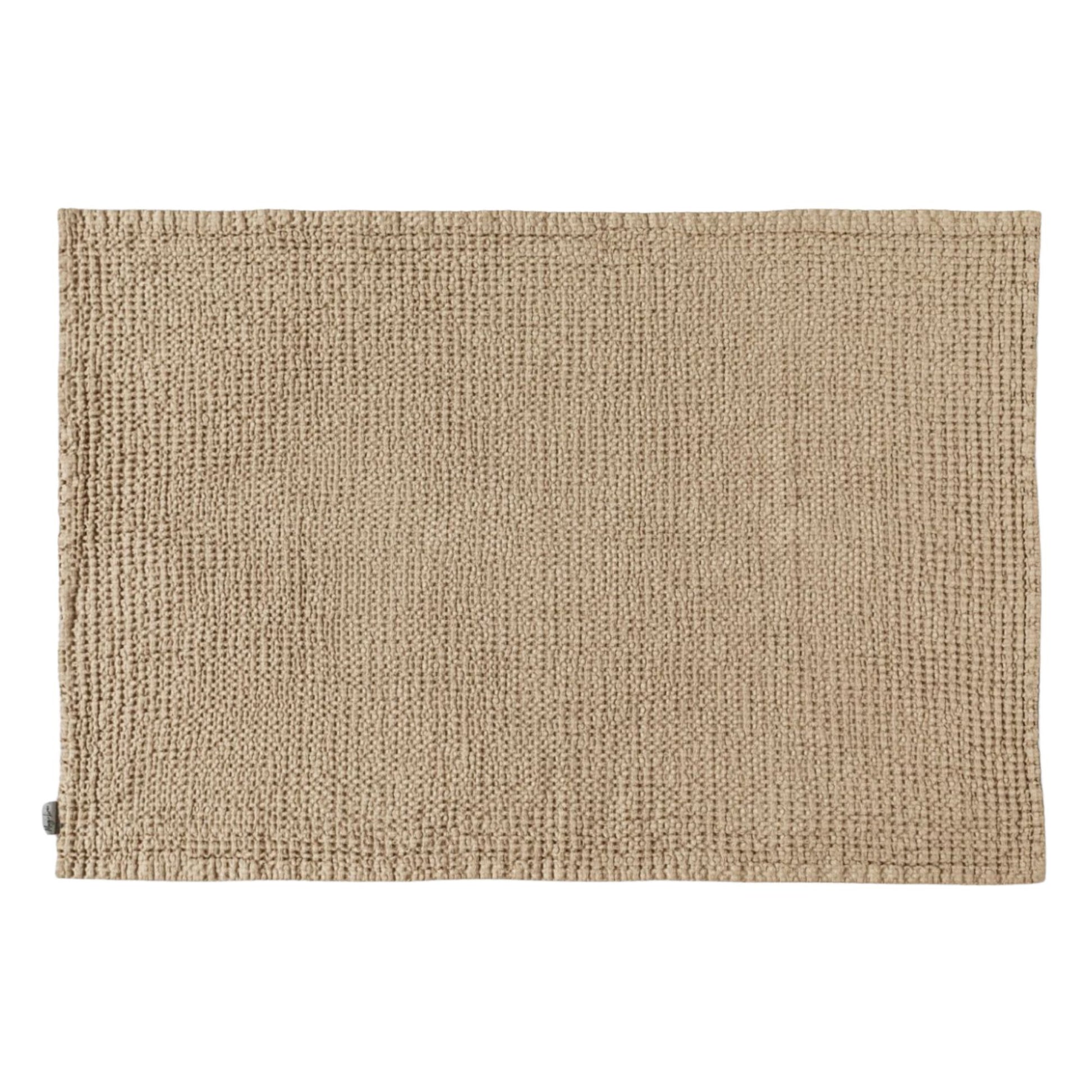  Badematte i beige med vaffelstruktur, laget av lin – et naturlig og pustende valg for et sunnere baderomsmiljø.