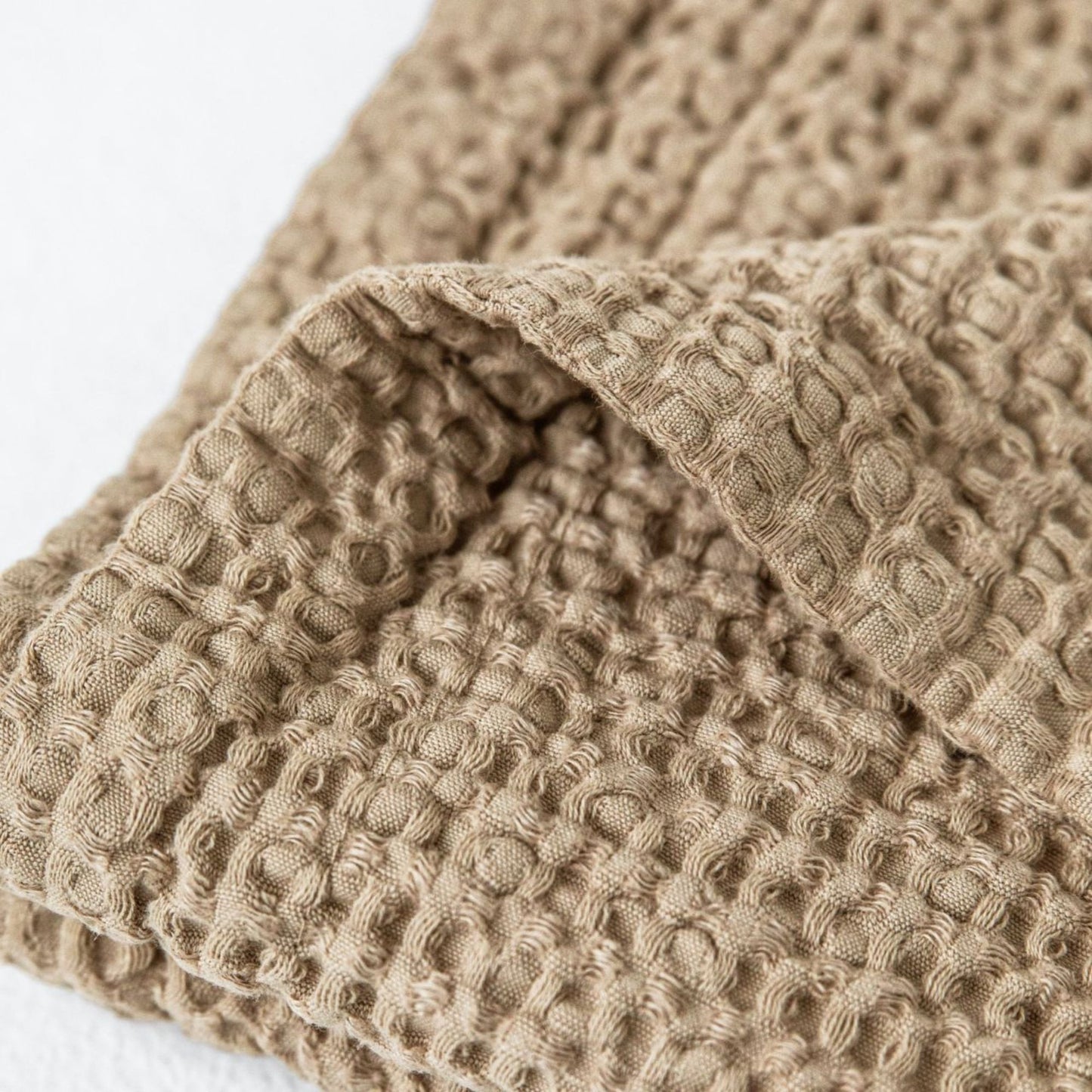 Håndlaget beige badematte i lin med karakteristisk waffle-mønster –naturlig, vakker og bærekraftig.