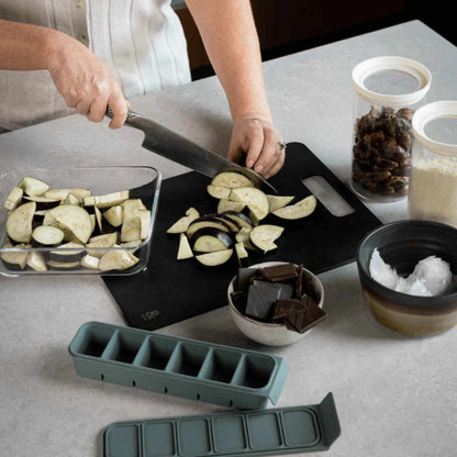 Wood fibre skjærefjøl i fargen Liquorice brukt til å kutte aubergine på kjøkkenbenk.