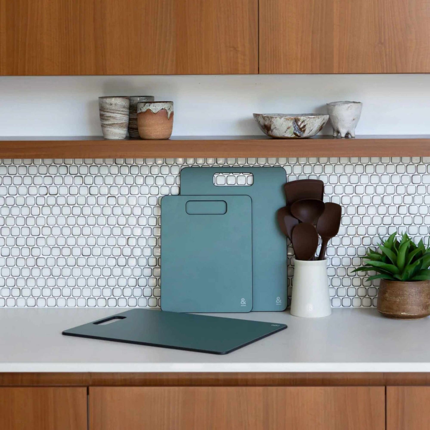 Wood fibre skjærefjøler i fargen Eucalyptus stående på kjøkkenbenk.