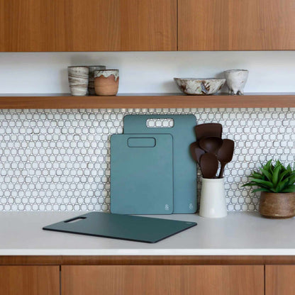 Wood fibre skjærefjøler i fargen Eucalyptus stående på kjøkkenbenk.