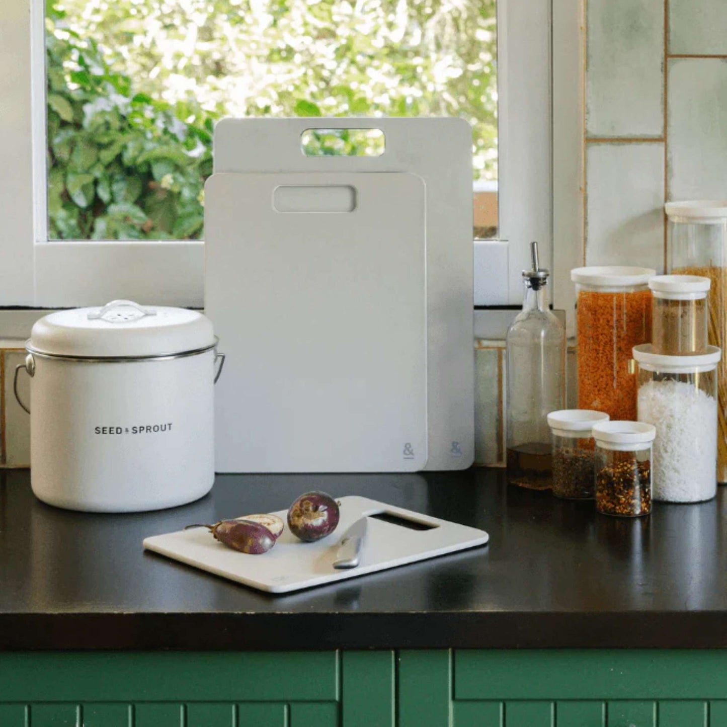 Wood fibre skjærefjøler i fargen Mushroom stående på kjøkkenbenk ved vindu.