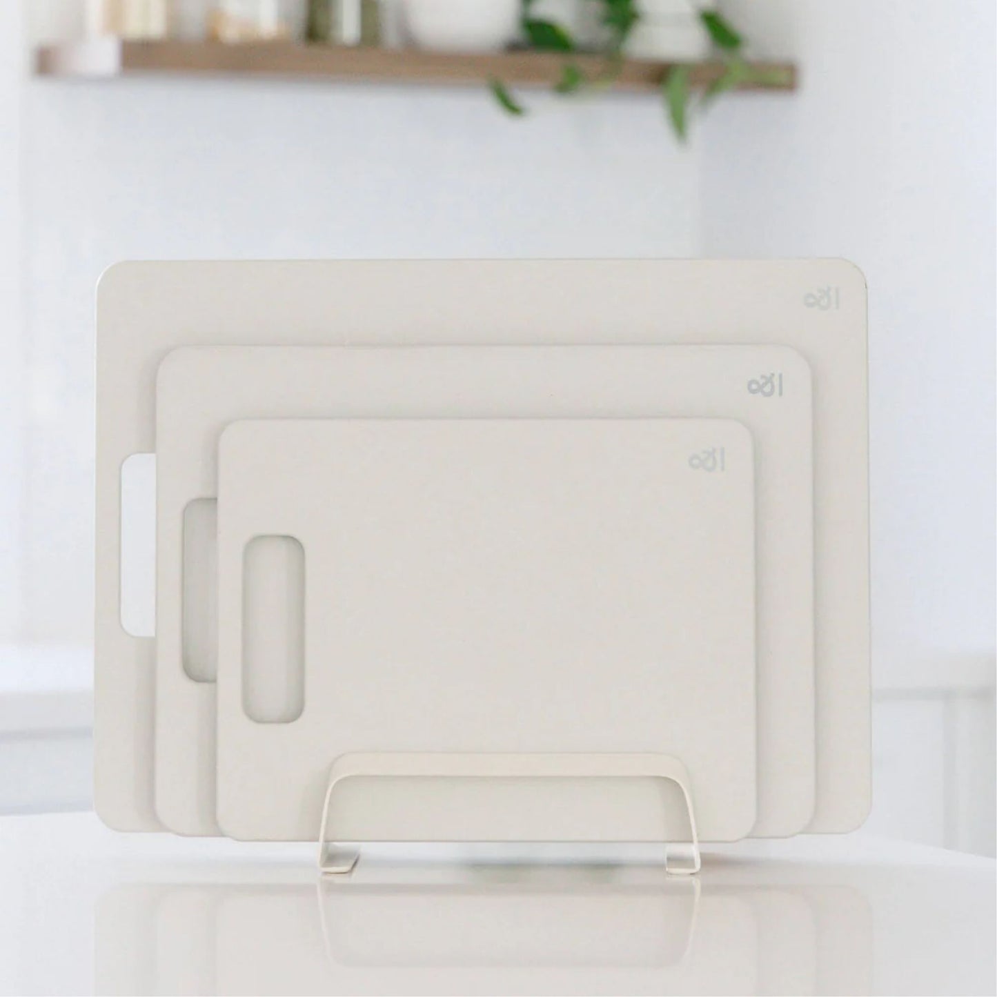 Wood fibre skjærefjøler i fargen Mushroom vist i tre størrelser på kjøkkenbenk.